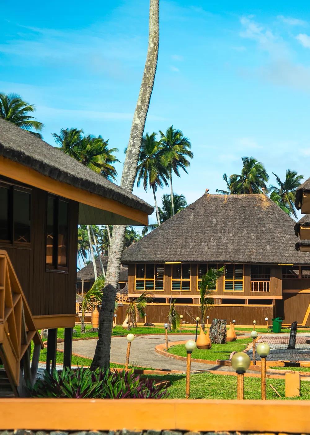 Beachfront resort huts surrounded by palm trees